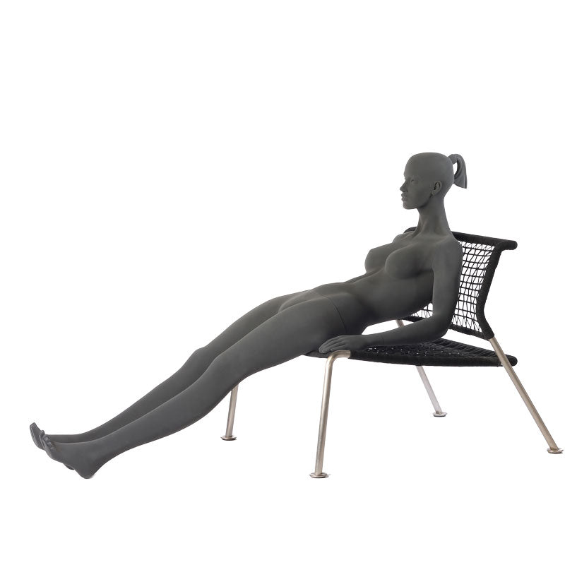Stylised female mannequin in a sitting pose with straight legs.
